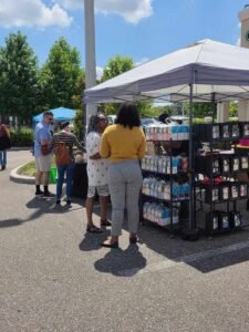 two women talking about what they are selling at sunday market jacksonville