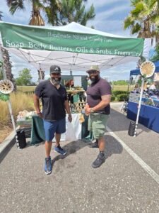 two guys in front of booth at a sunday market jacksonville