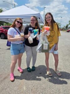 three girls at a holding what they bought at sunday market jacksonville