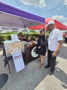 a couple viewing a dessert booth at sunday market jacksonville